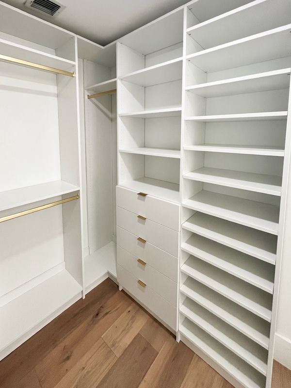 White closet with gold rods and pulls