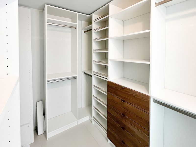 White closet with walnut drawers and shoe shelves