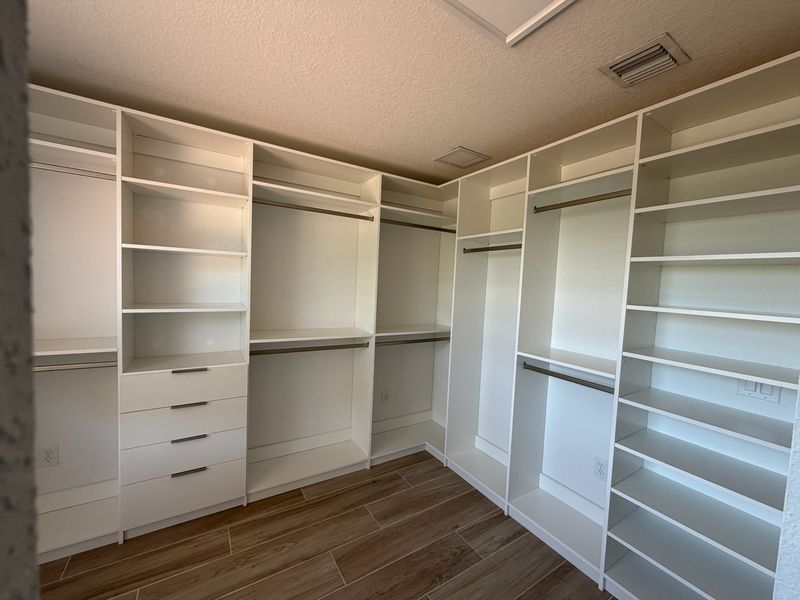 White walk-in closet with drawers and double hanging